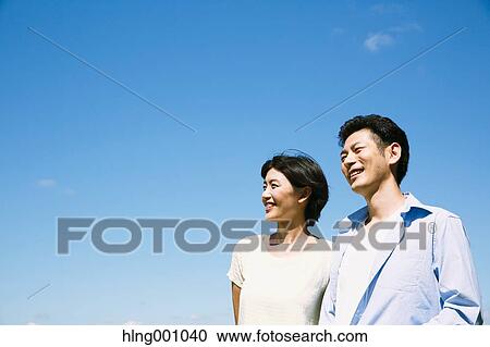 Stock Image - Happy Japanese couple in a park. Fotosearch