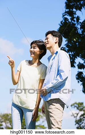 Stock Image - Happy Japanese couple in a park. Fotosearch