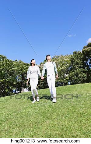 Stock Image - Happy Japanese couple in a park. Fotosearch