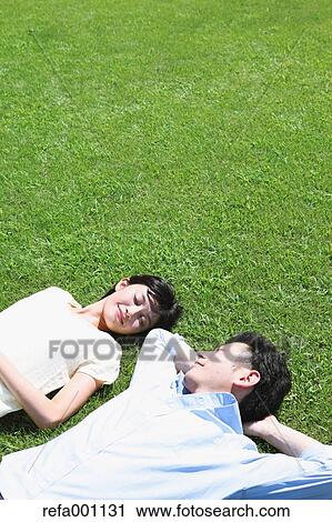 Happy Japanese couple laying on grass in a park View Large Photo Image Stock Image - Happy Japanese couple laying on grass in a park. Fotosearch