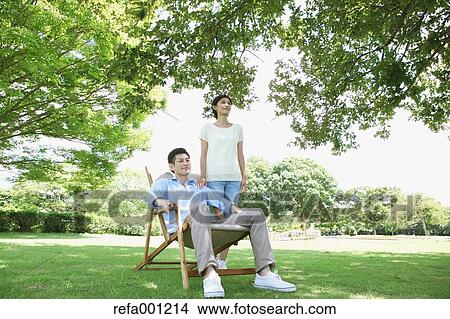 Happy Japanese couple with deck chair in a park View Large Photo Image Picture - Happy Japanese couple with deck chair in a park. Fotosearch