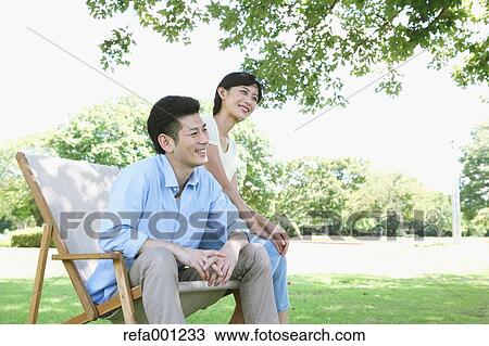 Happy Japanese couple with deck chair in a park View Large Photo Image Stock Image - Happy Japanese couple with deck chair in a park. Fotosearch