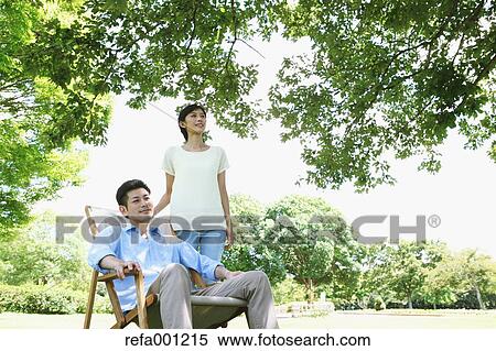 Happy Japanese couple with deck chair in a park View Large Photo Image Stock Photography - Happy Japanese couple with deck chair in a park. Fotosearch