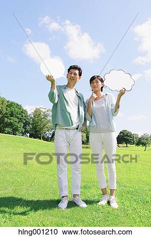 Happy Japanese couple with whiteboards in a city park View Large Photo Image Stock Image - Happy Japanese couple with whiteboards in a city park. Fotosearch
