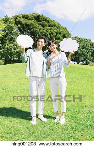 Happy Japanese couple with whiteboards in a city park View Large Photo Image Stock Photo - Happy Japanese couple with whiteboards in a city park. Fotosearch