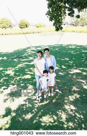 Stock Image - Happy Japanese family in a city park. Fotosearch