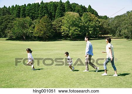 Stock Image - Happy Japanese family in a city park. Fotosearch