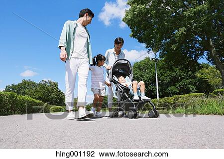 Stock Image - Happy Japanese family in a city park. Fotosearch