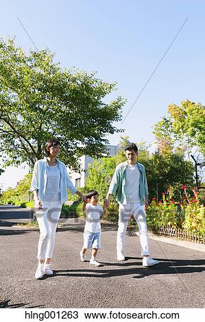 Stock Image - Happy Japanese family in a city park. Fotosearch