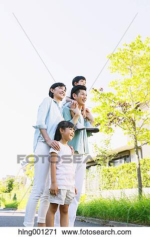 Stock Image - Happy Japanese family in a city park. Fotosearch