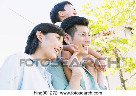 Stock Image - Happy Japanese family in a city park. Fotosearch