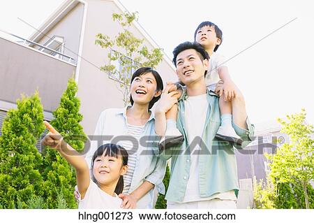 Stock Image - Happy Japanese family in a city park. Fotosearch