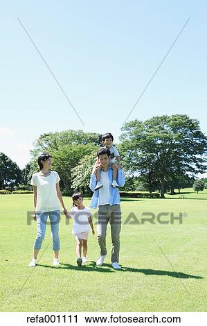 Stock Image - Happy Japanese family in a city park. Fotosearch