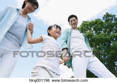 Stock Photo - Happy Japanese family in a city park. Fotosearch