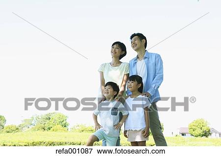 Stock Photo - Happy Japanese family in a city park. Fotosearch