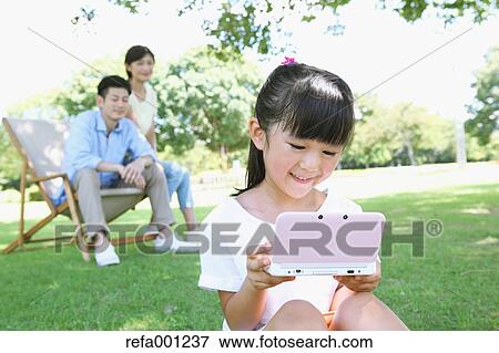 Stock Photo - Happy Japanese family in a city park. Fotosearch