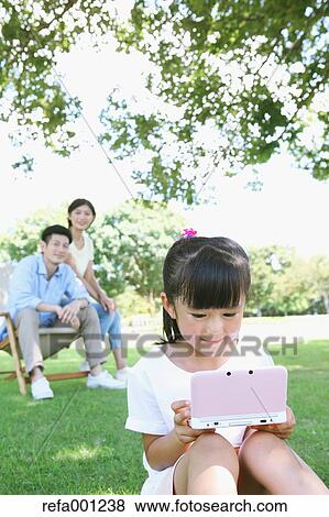 Happy Japanese family in a city park View Large Photo Image Stock Photo - Happy Japanese family in a city park. Fotosearch