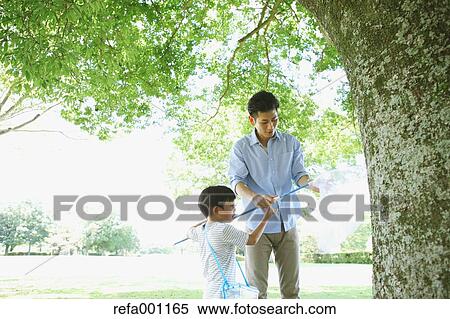 Happy Japanese father and son catching insects in a city park View Large Photo Image Stock Photography - Happy Japanese father and son catching insects in a city park. Fotosearch