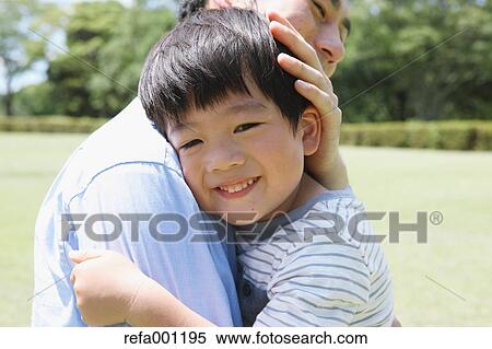 Happy Japanese father and son hugging in a city park View Large Photo Image Stock Photography - Happy Japanese father and son hugging in a city park. Fotosearch
