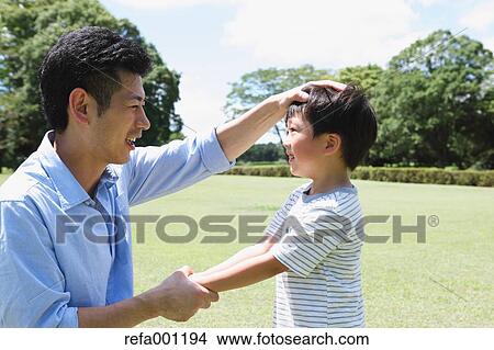 Happy Japanese father and son in a city park View Large Photo Image Picture - Happy Japanese father and son in a city park. Fotosearch