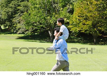 Happy Japanese father and son in a city park View Large Photo Image Stock Image - Happy Japanese father and son in a city park. Fotosearch