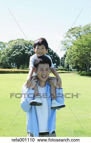 Happy Japanese father and son in a city park View Large Photo Image Stock Image - Happy Japanese father and son in a city park. Fotosearch