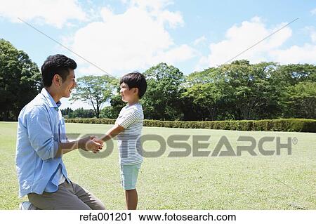 Happy Japanese father and son in a city park View Large Photo Image Stock Image - Happy Japanese father and son in a city park. Fotosearch