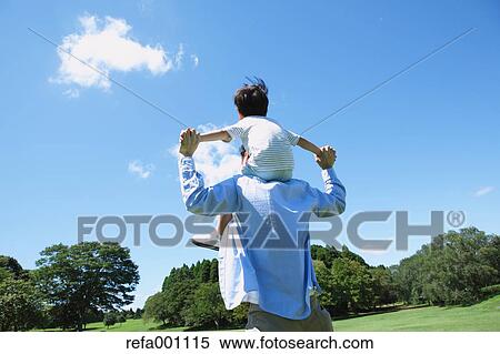 Stock Photography - Happy Japanese father and son in a city park. Fotosearch