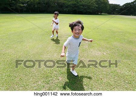 Stock Image - Happy Japanese kids in a city park. Fotosearch