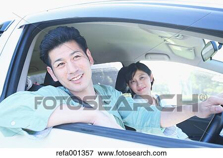 Stock Photo - Japanese couple riding a car in nature. Fotosearch