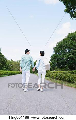Stock Photo - Japanese couple walking in a city park. Fotosearch