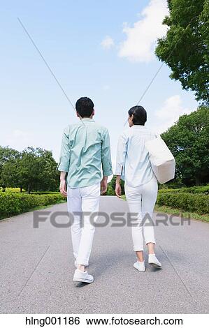 Japanese couple walking in a city park View Large Photo Image Stock Photograph - Japanese couple walking in a city park. Fotosearch