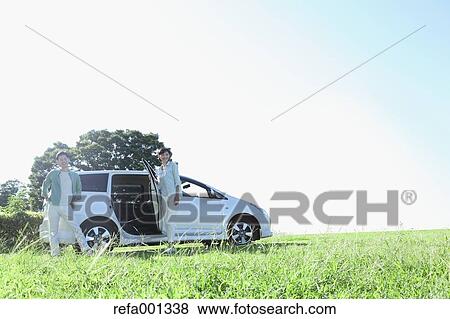 Stock Photo - Japanese couple with car in a city park. Fotosearch