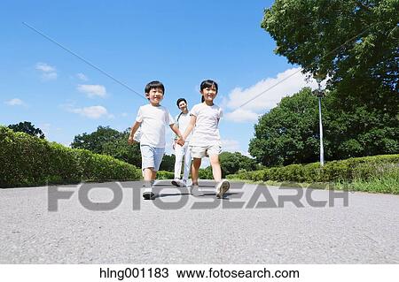 Japanese father playing with his kids in a city park View Large Photo Image Stock Image - Japanese father playing with his kids in a city park. Fotosearch