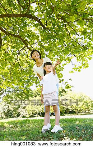 Japanese mother and daughter in a city park View Large Photo Image Stock Image - Japanese mother and daughter in a city park. Fotosearch