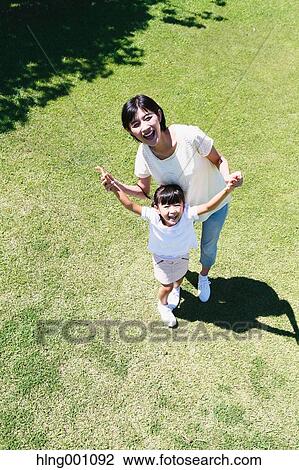 Stock Image - Japanese mother and daughter in a city park. Fotosearch