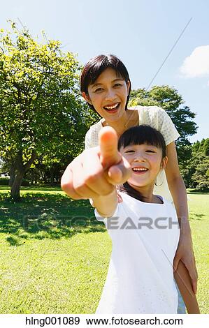Stock Photo - Japanese mother and daughter in a city park. Fotosearch