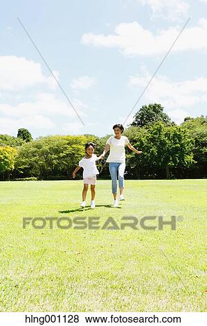 Stock Photo - Japanese mother and daughter in a city park. Fotosearch