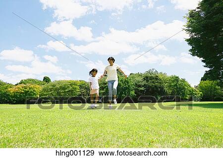 Stock Photo - Japanese mother and daughter in a city park. Fotosearch