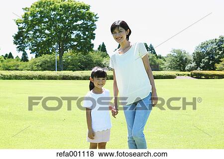 Stock Photo - Japanese mother and daughter in a city park. Fotosearch