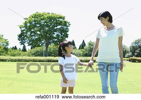 Stock Photo - Japanese mother and daughter in a city park. Fotosearch