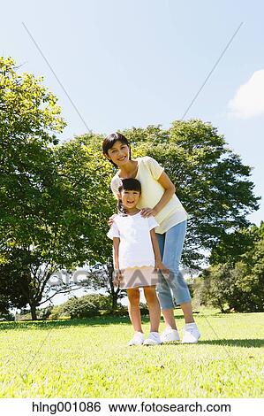 Stock Photograph - Japanese mother and daughter in a city park. Fotosearch