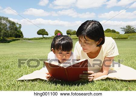 Japanese mother and daughter reading a book in a city park View Large Photo Image Stock Image - Japanese mother and daughter reading a book in a city park. Fotosearch