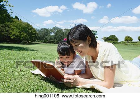 Japanese mother and daughter reading a book in a city park View Large Photo Image Stock Photography - Japanese mother and daughter reading a book in a city park. Fotosearch