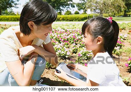 Japanese mother and daughter with tablet in a city park View Large Photo Image Stock Photo - Japanese mother and daughter with tablet in a city park. Fotosearch