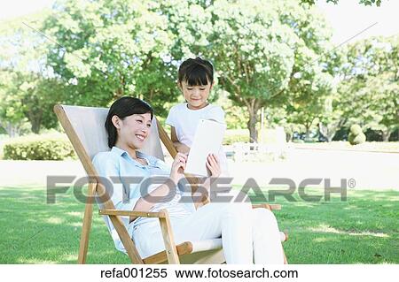 Japanese mother and daughter with tablet in a city park View Large Photo Image Stock Photography - Japanese mother and daughter with tablet in a city park. Fotosearch