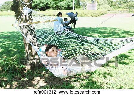 Stock Image - Japanese mother with kids in a city park. Fotosearch