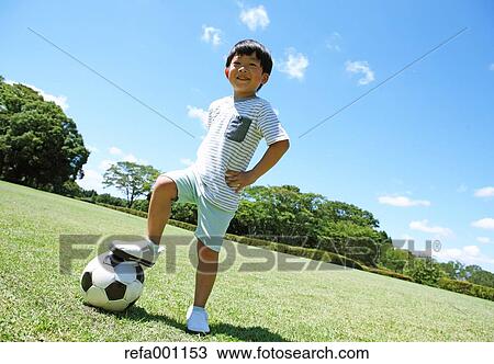 Japanese young boy playing soccer in a city park View Large Photo Image Stock Image - Japanese young boy playing soccer in a city park. Fotosearch