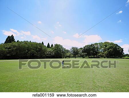 Japanese young boy playing soccer in a city park View Large Photo Image Stock Photo - Japanese young boy playing soccer in a city park. Fotosearch