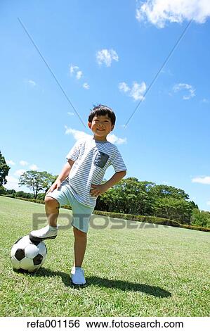 Japanese young boy playing soccer in a city park View Large Photo Image Stock Photograph - Japanese young boy playing soccer in a city park. Fotosearch